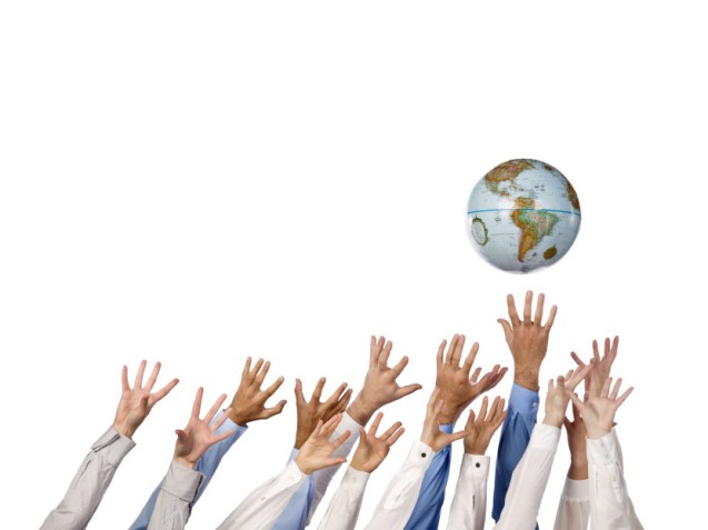 multi ethnic hands reaching for globe ball